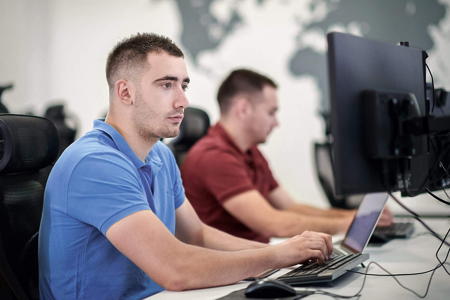 Zwei M&auml;nner arbeiten konzentriert am Computer in einem modernen B&uuml;ro.